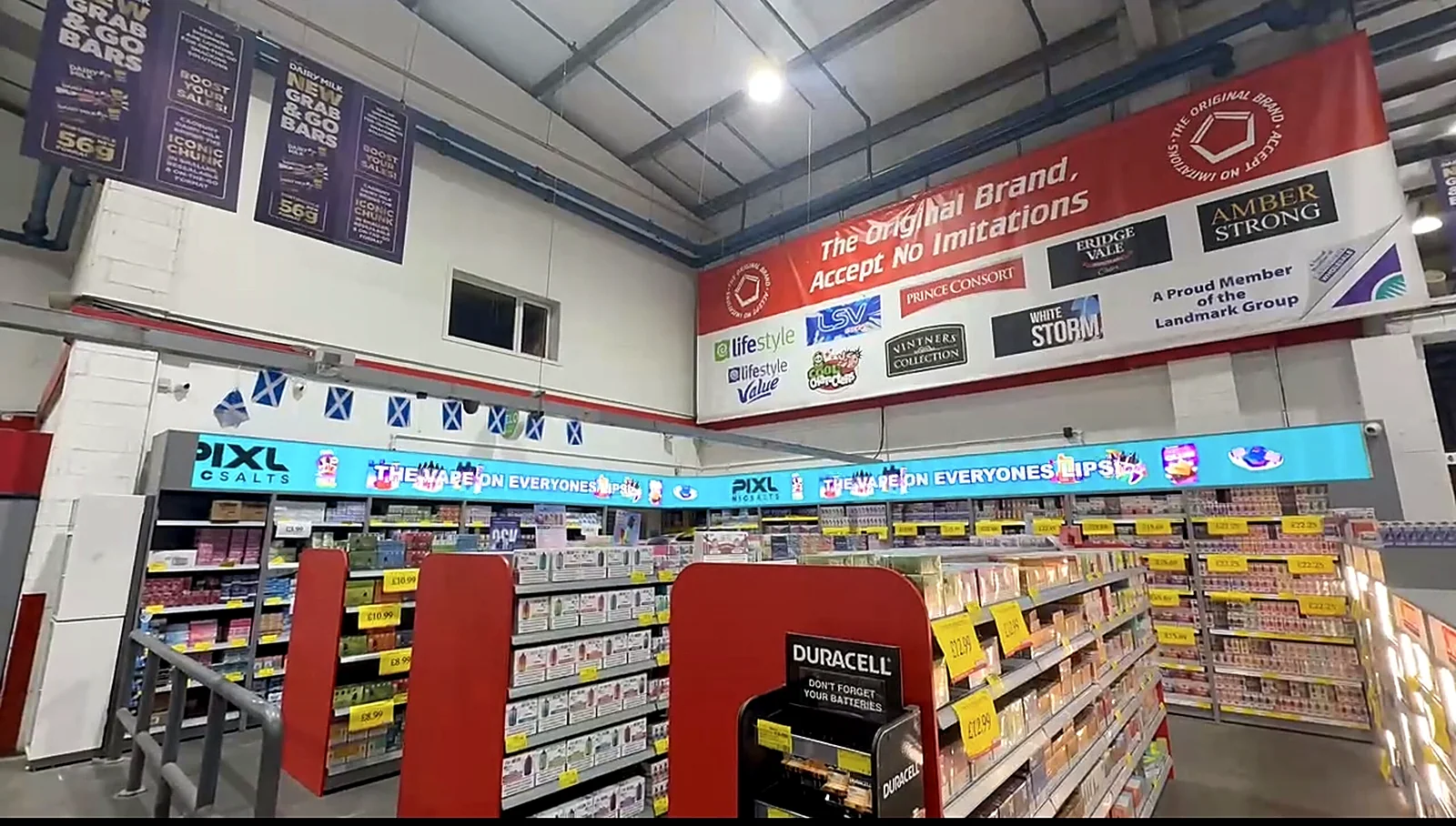 Curved LED ribbon display above the shelving of a convenience store